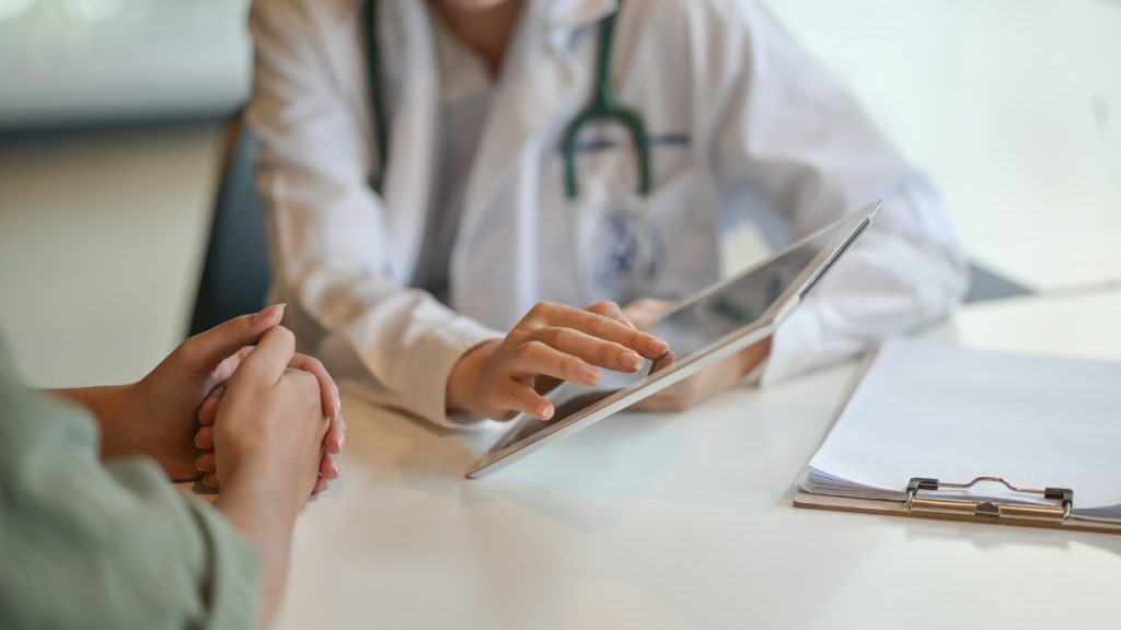 doctor showing patient information on a tablet - ehr optimization