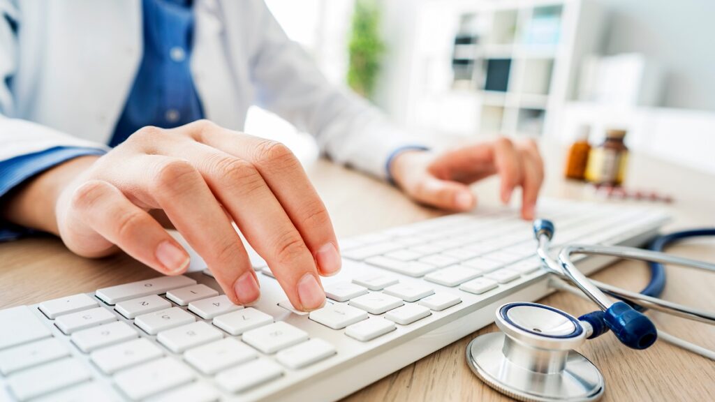 doctor typing on keyboard - is medical transcription still in demand