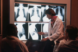 Doctor looking at xrays and recording audio that medical transcription will work with later